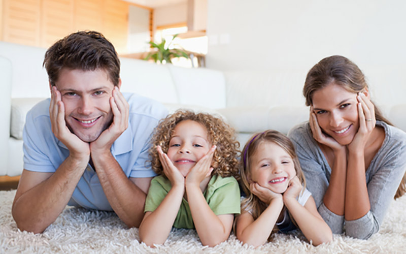 happy family lying on carpet in living room happy family lying on carpet in living room